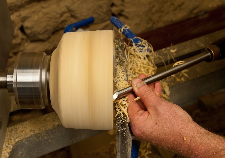 Detailed image of a craftsman woodturning in a workshop in Normandy, France.