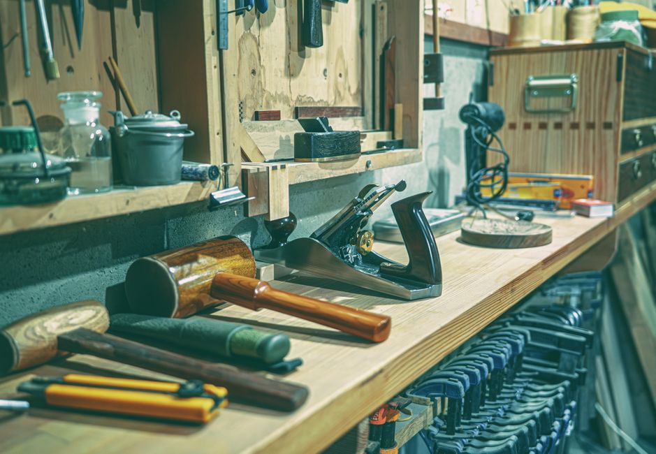 A tidy workshop bench with various woodworking tools and clamps neatly arranged.